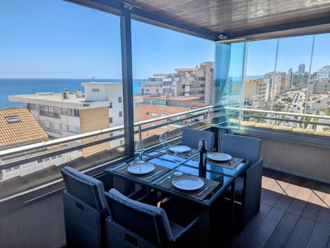Glazed terrace with dining table and a wide sea view